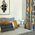 Modern ingerichte slaapkamer met Elitis Escale-gordijnen, grafische kussens en kunst aan de muur.
