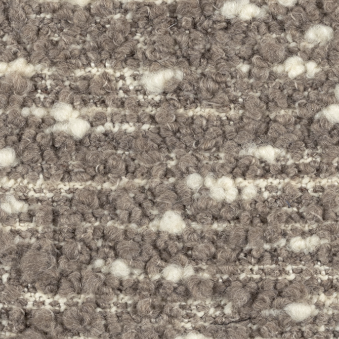 Close-up van de Elitis Horizon LI 875 05 meubelstof met een grofgeweven boucléstructuur in beige- en crèmetinten.
