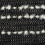 Detail van Elitis-stof Horizon LI 875 80 met een geweven zwart-wit patroon en lussen van witte wol.