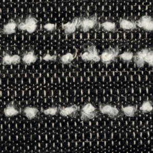 Detail van Elitis-stof Horizon LI 875 80 met een geweven zwart-wit patroon en lussen van witte wol.