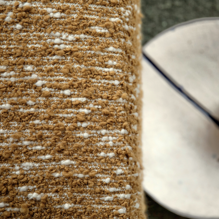 Detail van Elitis-stof Horizon met een grof geweven textuur in bruin en wit.