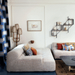 Moderne woonkamer met Elitis-stoffen, grafische kussens, en een sfeervol interieur bij Buningh Wonen.
