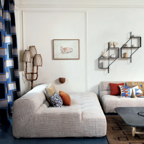 Moderne woonkamer met Elitis-stoffen, grafische kussens, en een sfeervol interieur bij Buningh Wonen.