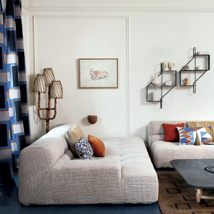 Moderne woonkamer met Elitis-stoffen, grafische kussens, en een sfeervol interieur bij Buningh Wonen.