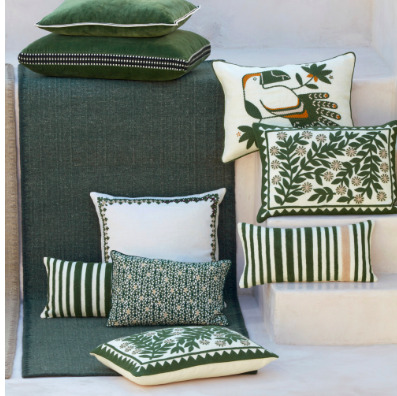 Groen Elitis Tenere TA 126 vloerkleed met decoratieve kussens in botanische en gestreepte patronen.
