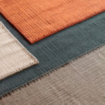 Detailopname van het Elitis Tenere vloerkleed TA 126 in vier kleuren met zichtbare textuur en weefpatroon.