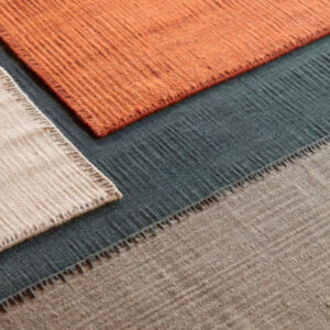 Detailopname van het Elitis Tenere vloerkleed TA 126 in vier kleuren met zichtbare textuur en weefpatroon.