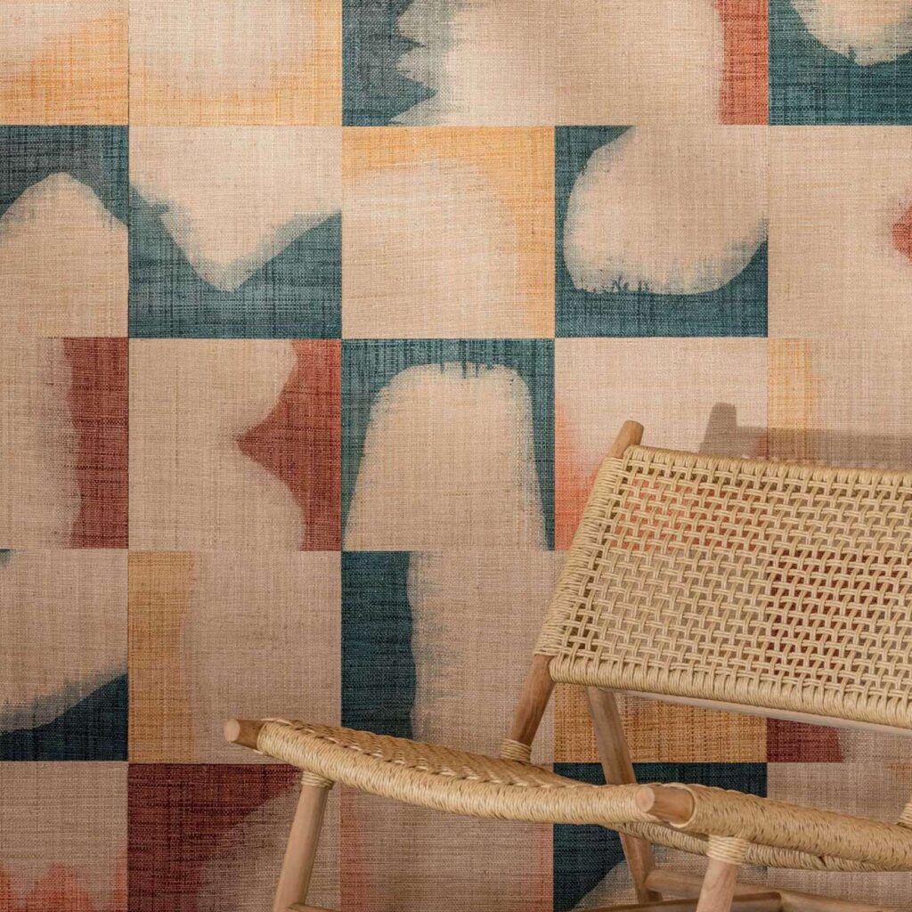 Vlechtstoel voor een kleurrijk behang met abstract geometrisch patroon uit de Elitis Tribus Comporta RM 1079-58 collectie.