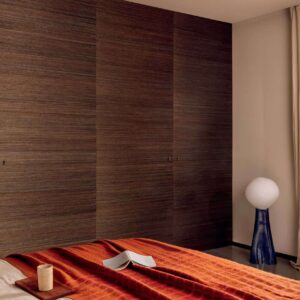 Sfeervolle slaapkamer met Elitis Tribus Favoris RM 1070 04 wandbekleding, rood dekbed en moderne verlichting.