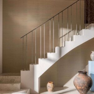Moderne interieursetting met een witte trap en Elitis Tribus Favoris RM 1070 wandbekleding, omlijst door aardewerken vazen.