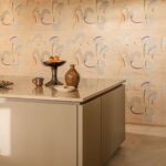 Moderne keuken met marmeren aanrechtblad en Elitis Tribus Lazgi RM 1100 01-behang met abstract patroon op de achtergrond.