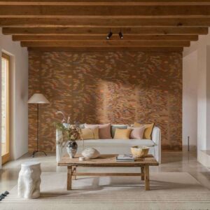 Sfeervolle woonkamer met Elitis Tribus Samarkand RM 1098 15 behang, een witte bank met pastelkleuren kussens en een houten salontafel.