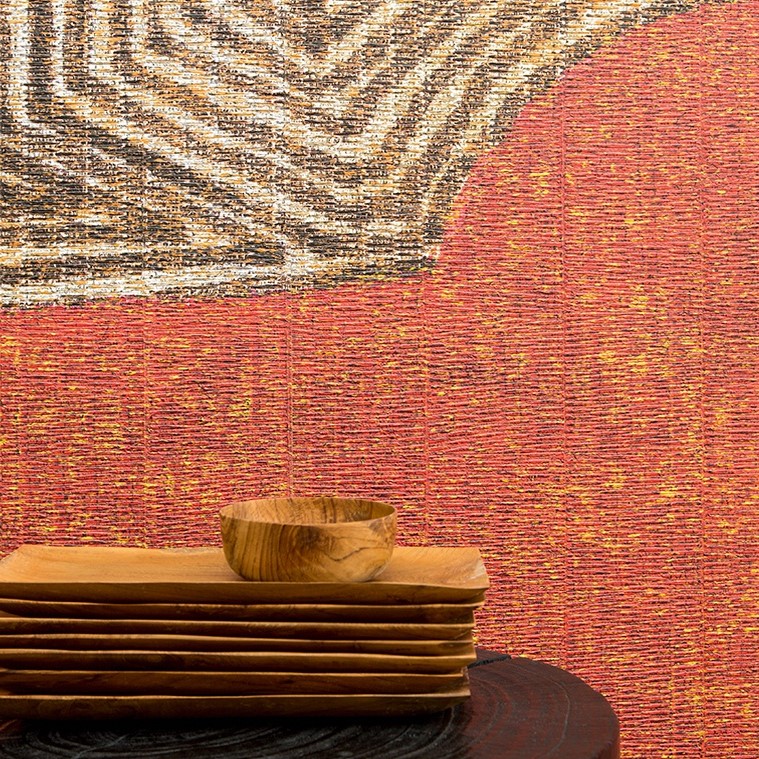 Houten schalen op een donkerhouten tafel voor een kleurrijk Elitis NATURAL MOOD Mexicas wandpaneel met abstract patroon.