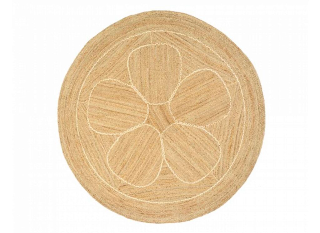 Rond jute vloerkleed met een bloemvormig patroon in het midden.
