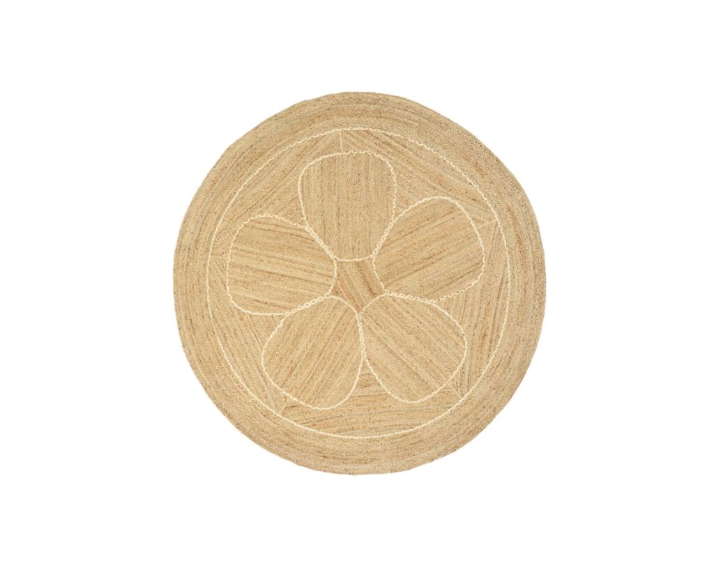 Rond vloerkleed van jute met een bloemvormig patroon in het midden.