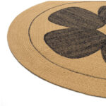 Detail van het ronde Eltis Amapola TA 129 81 07 vloerkleed met een zwart bloemmotief op een beige achtergrond.
