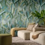 Moderne zithoek met beige meubels en een decoratieve groen-blauwe bladerenprint op de muur uit de Essentials Les Tricots 73103 collectie.