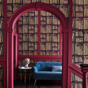 Interieur met Fornasetti Ex Libris-behang met boekmotief, een donkerroze boog en een blauwe bank.
