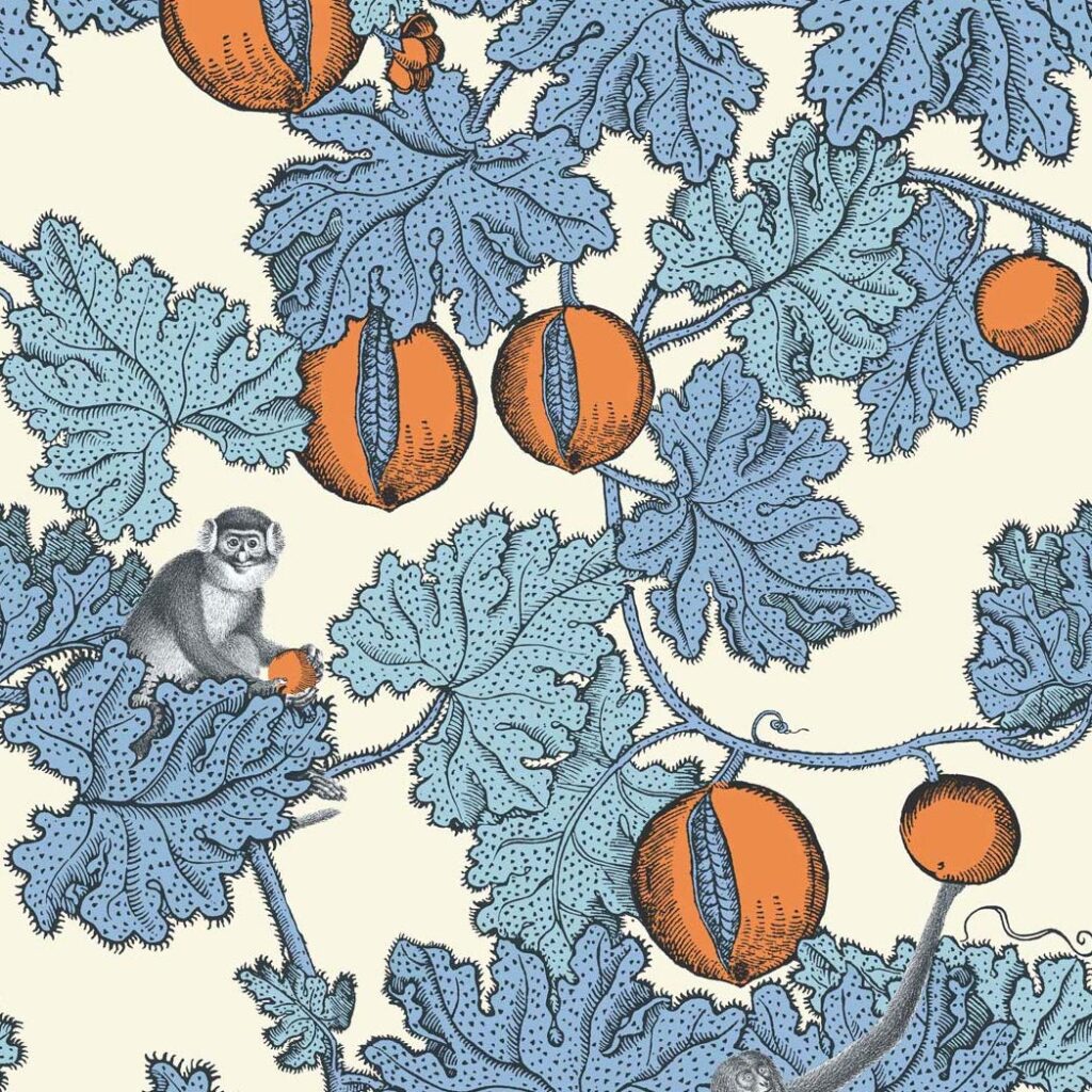 Fornasetti-behang met blauwe bladeren, oranje vruchten en tekeningen van apen tussen het gebladerte.