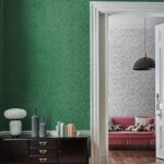 Interieur met groen Fornasetti Malachite-behang en doorkijk naar kamer met zwart-witte variant en roze bank.