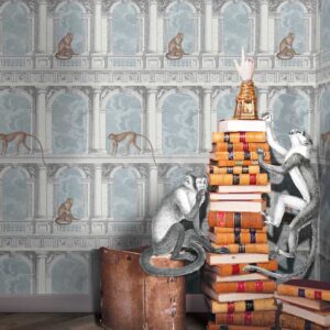 Illustratief Fornasetti-behang 'Procuratie con vista' met apen in een klassieke architecturale setting, gecombineerd met illustraties van apen die opgestapelde boeken beklimmen.