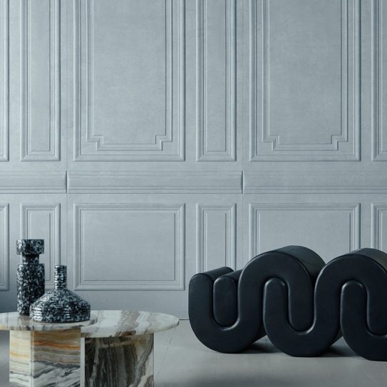 Moderne interieursetting met de Grandeur2-EXJN-2 fauteuil, een marmeren tafel en decoratieve vazen tegen een lichtgrijze, klassiek gelijnde wand.