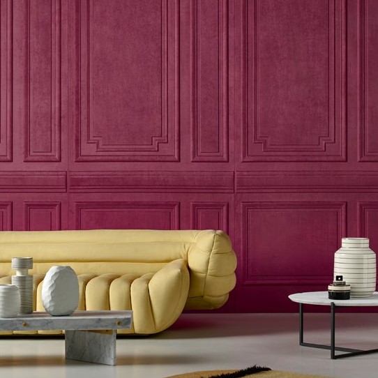 Moderne woonkamer met een gele designbank, marmeren salontafels en een dieprode Grandeur3-2PHM-2 wand met klassieke panelen.
