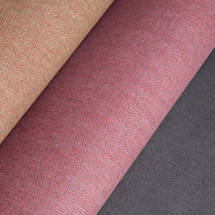 Drie opgerolde stoffen uit de LesUnis2-Q3GN collectie in beige, rood en donkergrijs met fijne textuur.