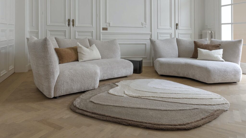 Luxe woonkamer met Limited Edition Agate High Travertine vloerkleed, omringd door zachte beige designbanken.