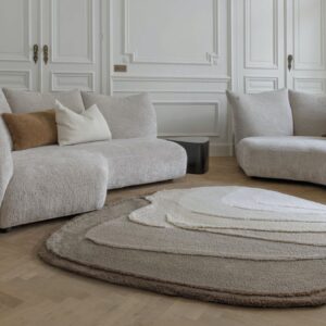Luxe woonkamer met Limited Edition Agate High Travertine vloerkleed, omringd door zachte beige designbanken.
