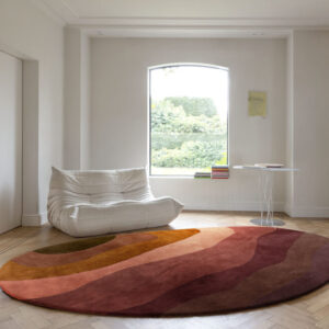 Rond vloerkleed in aardetinten uit de Limited Edition Allegro Low Aprico Brandy collectie in een minimalistisch ingerichte woonkamer.