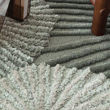 Detail van het Limited Edition Atoll vloerkleed in Aqua Organic met een organisch golvend patroon in zachte groentinten.