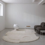Minimalistisch interieur met een Limited Edition vloerkleed in abstract organisch ellipse-patroon in neutrale tinten.