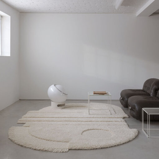 Minimalistisch interieur met een Limited Edition vloerkleed in abstract organisch ellipse-patroon in neutrale tinten.