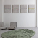 Modern interieur met het groene, organisch gevormde Limited Edition vloerkleed Astral Menthe, betonnen loungestoelen en minimalistische wandkunst.