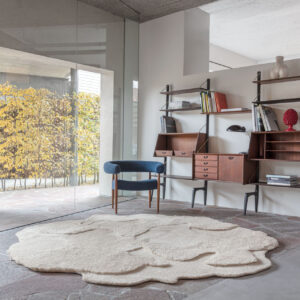 Modern interieur met het limited edition vloerkleed ‘Cosmic Cocoon Alabaster’ in organische vorm op een stenen vloer.