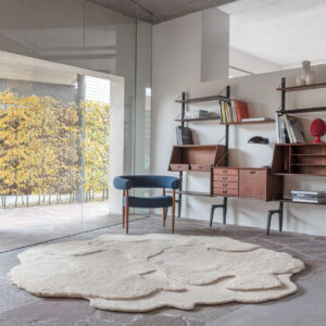 Modern interieur met het limited edition vloerkleed ‘Cosmic Cocoon Alabaster’ in organische vorm op een stenen vloer.