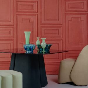 Moderne zithoek met een zwarte ronde tafel, beige stoelen en decoratieve vazen voor een rood paneelmuur.