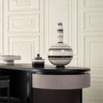 Strakke, moderne interieursetting met een zwart tafelblad en gestreepte decoratieve vazen uit de Manoir2-FZ4H-2 collectie.