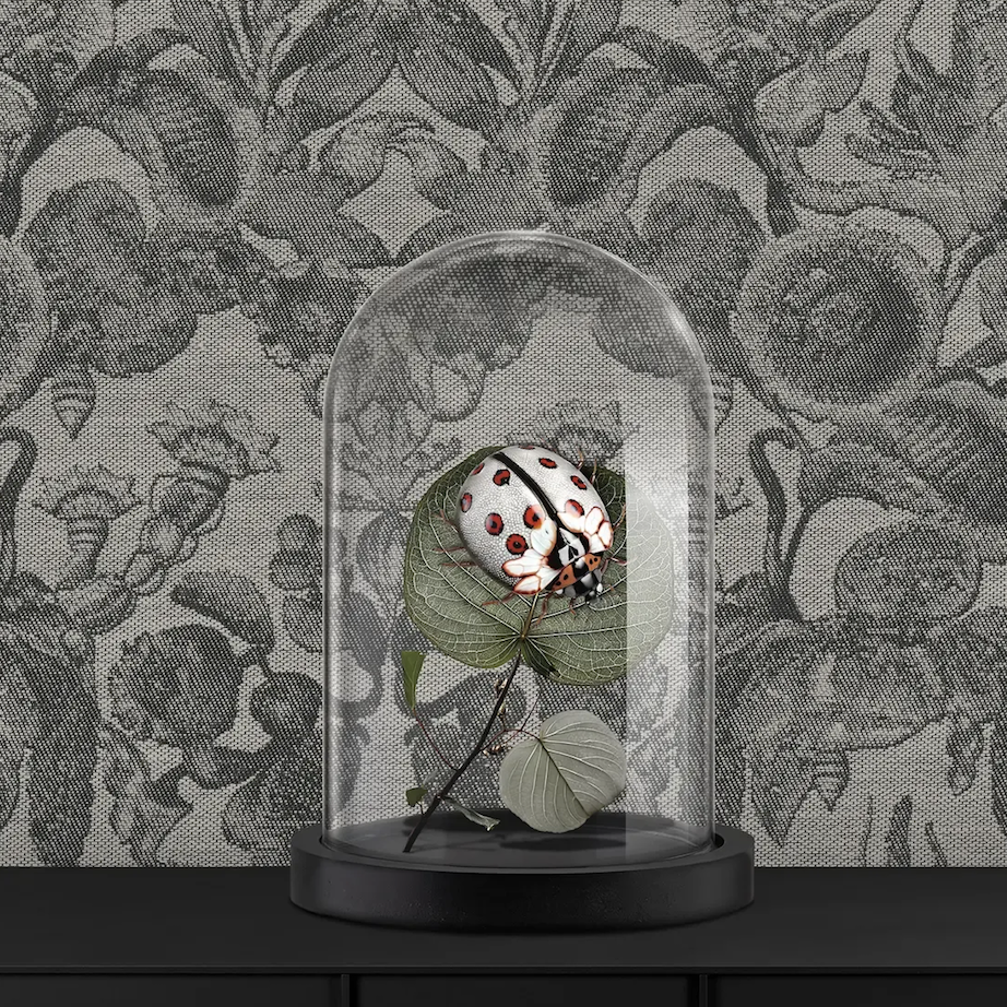 Decoratieve glazen stolp met een gestileerde lieveheersbeestje op een tak, voor jacquardbehang met bloemmotief uit de Moooi Coccinella Bella collectie.