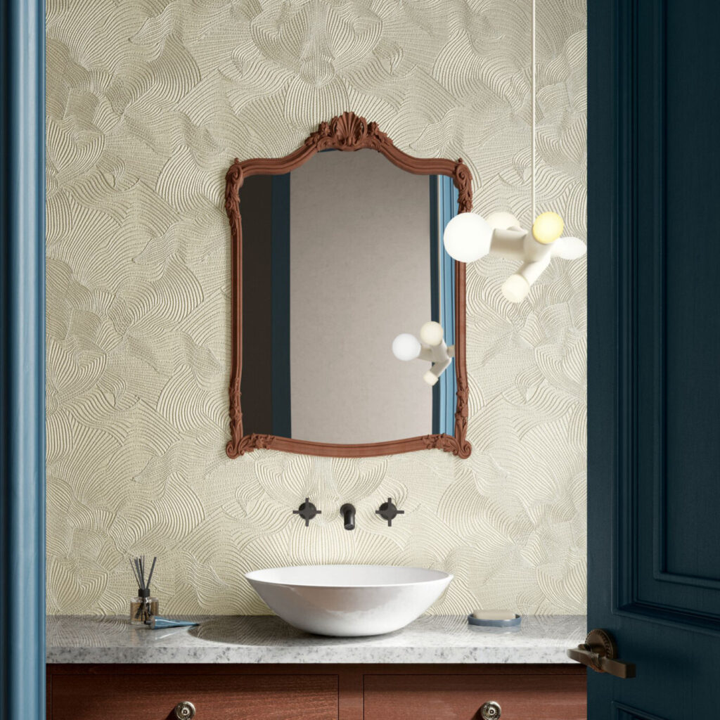 Stijlvol ingerichte badkamer met Moooi TechnoBee Embroidered MO5040-behang, een waskom op marmeren blad en een sierlijke houten spiegel.