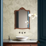 Stijlvol ingerichte badkamer met Moooi TechnoBee Embroidered MO5040-behang, een waskom op marmeren blad en een sierlijke houten spiegel.