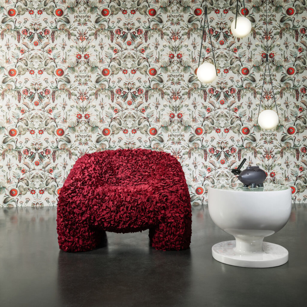 Rode designstoel voor een decoratieve Moooi Coccinella Bella wandbekleding met bloemen- en insectenmotief.