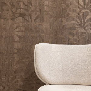 Close-up van een beige fauteuil voor een houtstructuur muur met beetle-varenpatroon van Moooi.