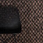 Zwart metalen stoel voor Moooi-behang met Aristo Quagga-patroon in zwart en bruin.