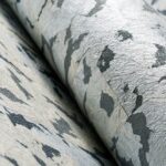 Detailopname van Moooi-behang ‘Armoured Boar’ met een zilverkleurige, metallic textuur en abstract camouflagepatroon.