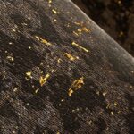 Close-up van het Moooi Bearded Leopard behang met een donker patroon en gouden accenten.