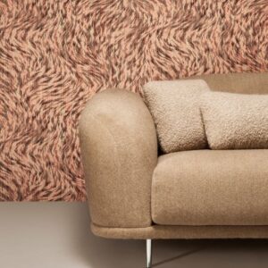 Beige bank voor een muur met het roze-bruine Moooi-behang Blushing Sloth met abstract patroon.