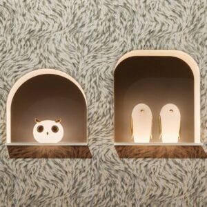 Twee verlichte nissen met decoratieve dierenfiguren tegen Moooi-behang Blushing Sloth.