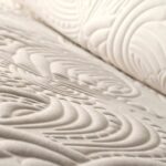Close-up van het Moooi Dodo Pavone behang met een reliëfpatroon in organische, golvende vormen.
